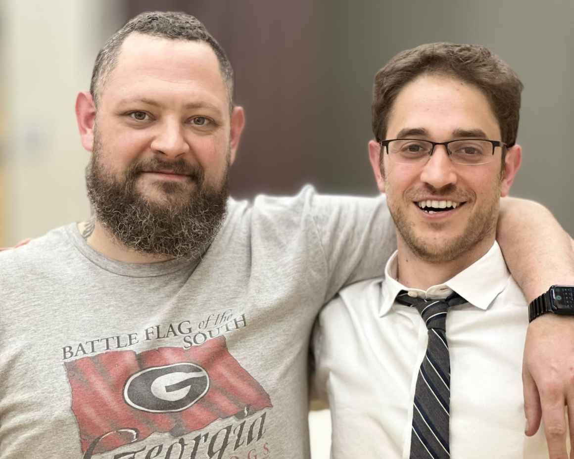 Photo of Eric in a University of Georgia T-shirt with his arm around Josh Malkin's shoulder