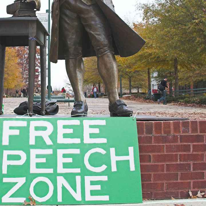 Free speech zone sign in front of statue