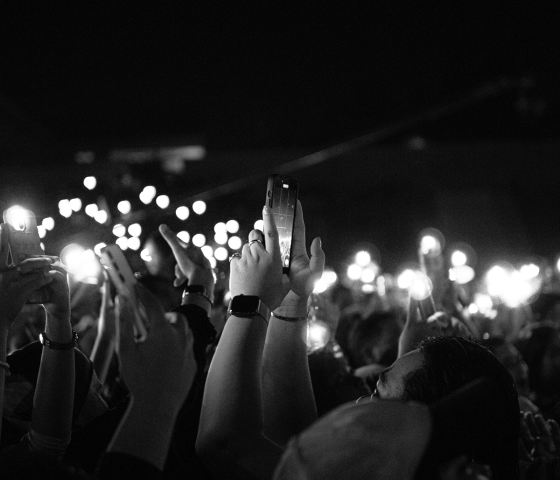 A crowd holds up smartphones with their flashlights on