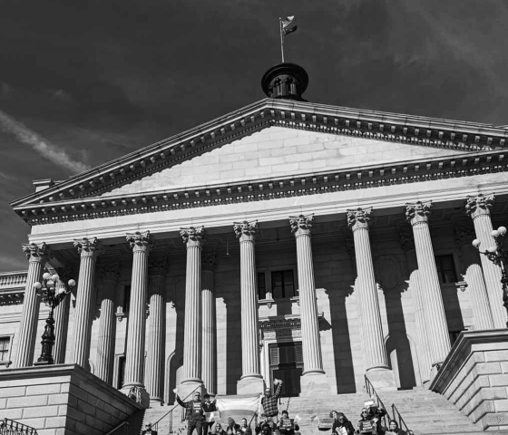 Grayscale photo of people gathered on the State House steps